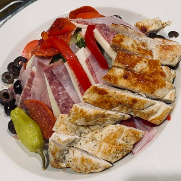 A Pastafina Italian salad with grilled chicken, salami, ham, cheese, olives, and peppers.