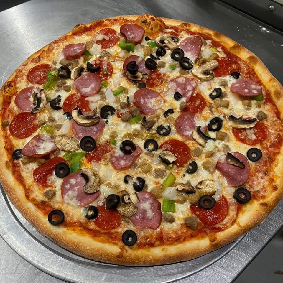 A Pastafina pizza with pepperoni, salami, sausage, mushrooms, olives, onions, and green peppers.
